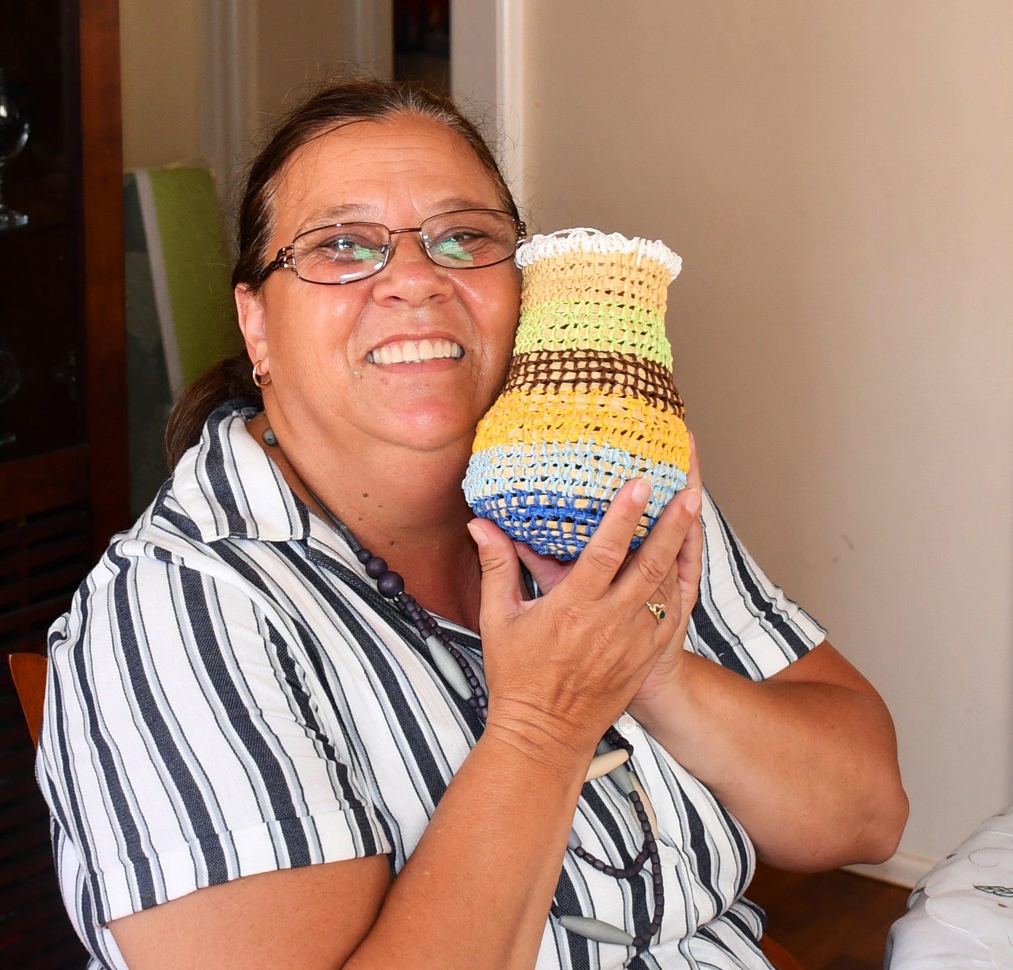 Woman holding a weaved Dillybag by Bigambul weaver Cheryl Moggs